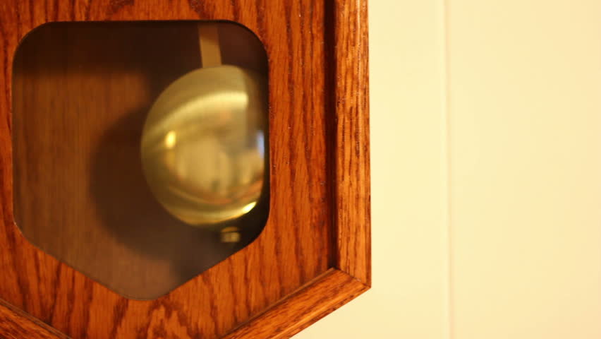 Close-up of the pendulum of a household wall clock.