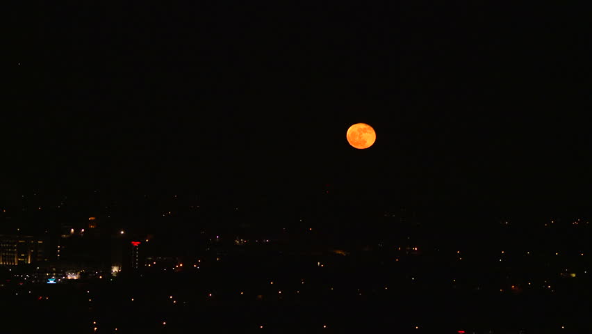 time-lapse of moon over city