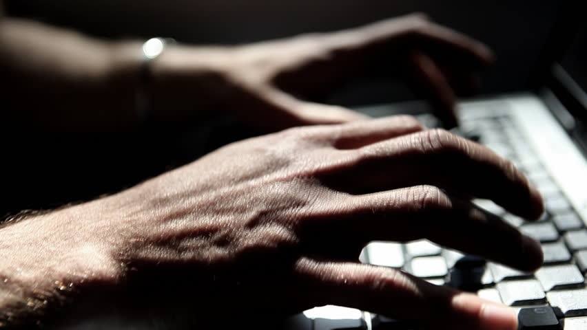 Close-up of hands working on laptop during a train ride, nice light effects by
