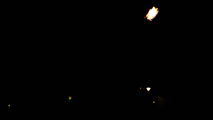 Silhouette of young girl playing poi in the night
