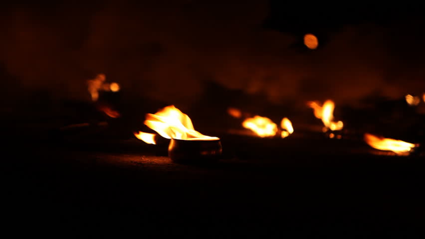 Several pots on the ground with burning fire