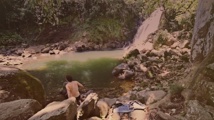 Male preparing to jump into natural pool