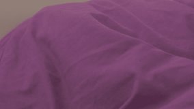 Beautiful blonde woman sleeping in the bed with purple covers 4K 2160p UHD footage - Woman dreaming in purple bed covers 4K 3840X2160 UHD video