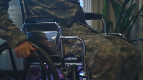 A veteran in camo moving in a wheelchair