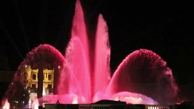 Magic fountain in Barcelona at night with pink and blue colors. Beautiful illuminated motion of water with special lighting.