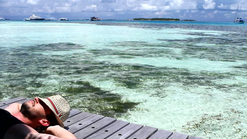 Handsome man resting near water at Maldives