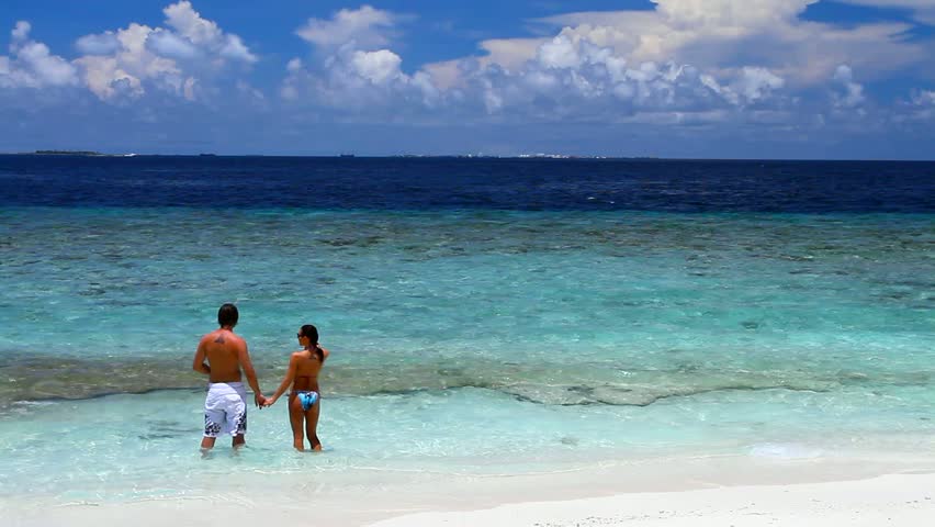 Romantic couple resting at Maldives seaside