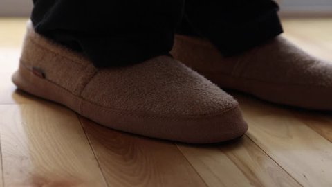 man slips on a pair of slippers