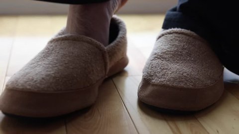 a man wears a pair of slippers dolly shot