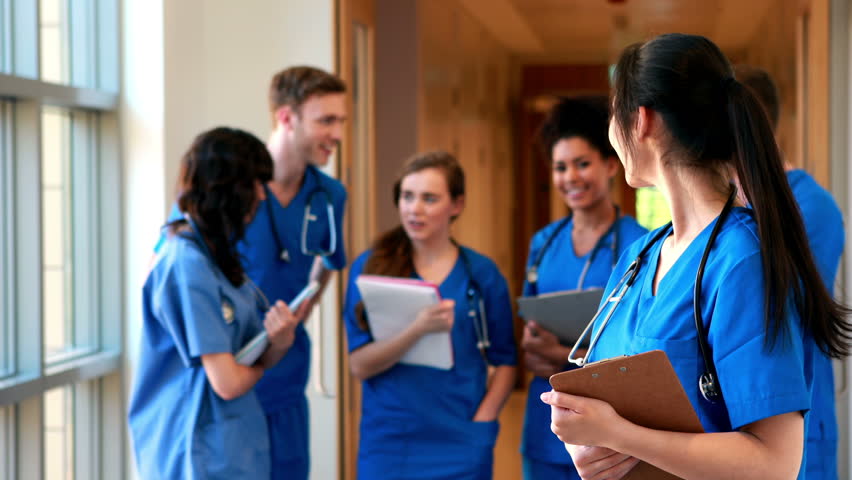 Multi-ethnic medical students chatting in hallway in high quality 4k format
