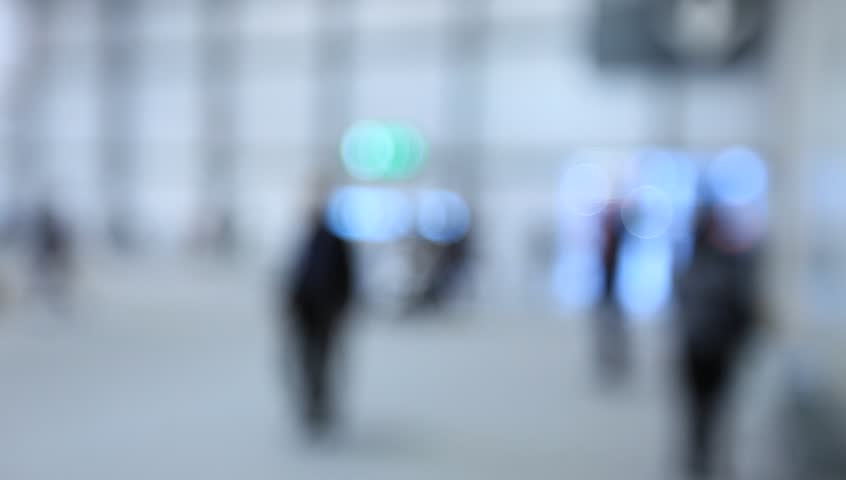 People walk visiting a trade show, generic background. Intentionally blurred post production.