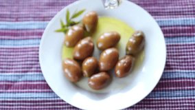 Adding olive oil to green olives