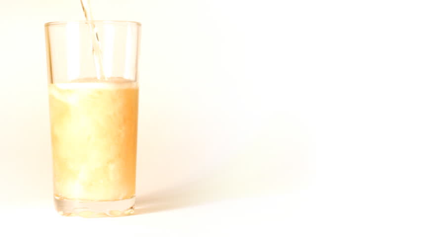 beer is poured into a glass on white background - slow motion