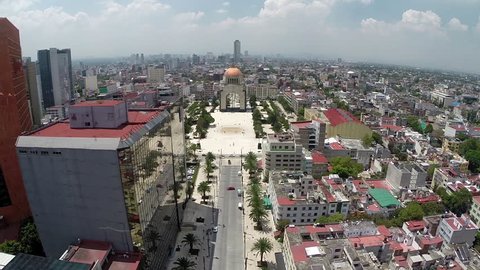 Aerial Shot of Republica's street, esplanade, Revolution Monument and some private and government buildings and a big sidewalk with palms near to Reforma Avenue in Mexico City