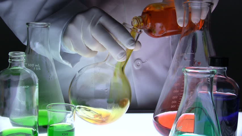 Scientist pours biofuel into flask and mixes
