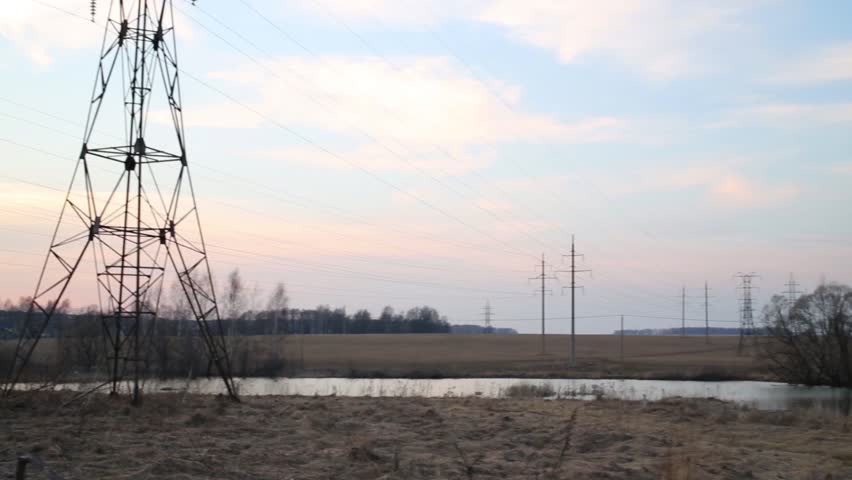 Transmission lines, field with dry grass and small river
