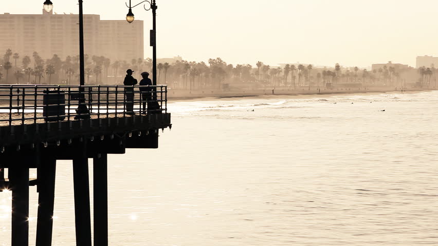 Silhouettes of people standing on Santa Monica Pier on a beautiful golden