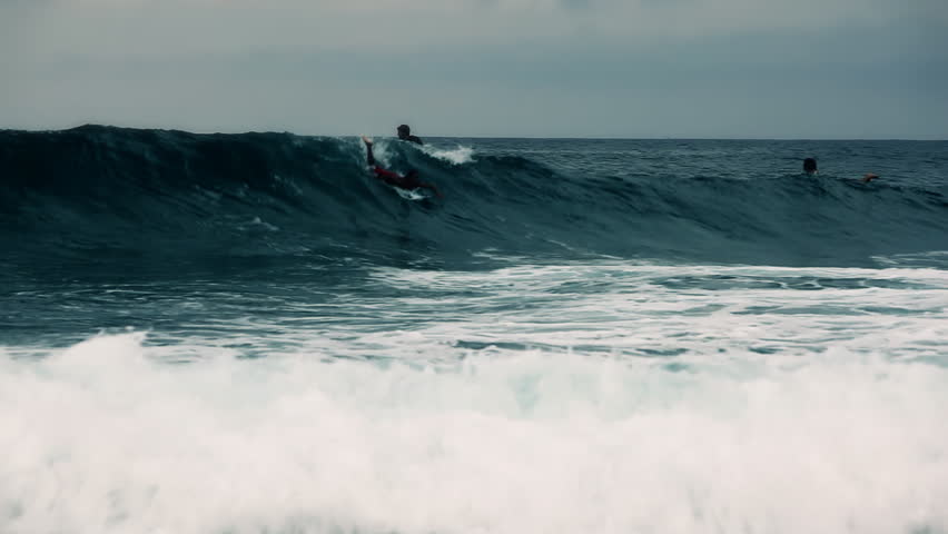 Surfer taking a wave and riding on it wildly