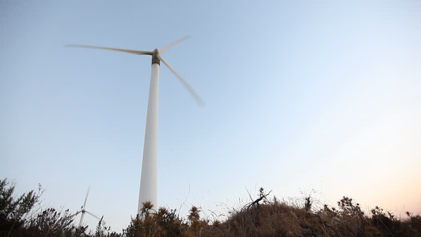 A big wind power machine standing in the nature in two different shots/exposures