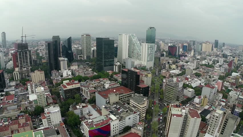 Aerial shot of Mexico City and lots of buildings in a busy day.