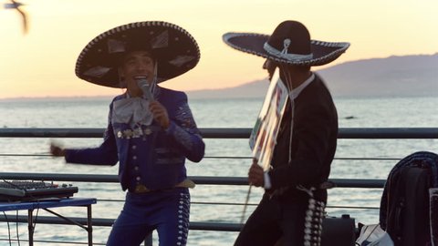 SANTA MONICA - JAN 14, 2015: festive Mexican Mariachi performers singing and dancing on pier for tourists in Los Angeles California. Santa Monica is a beachfront city in LA, CA.