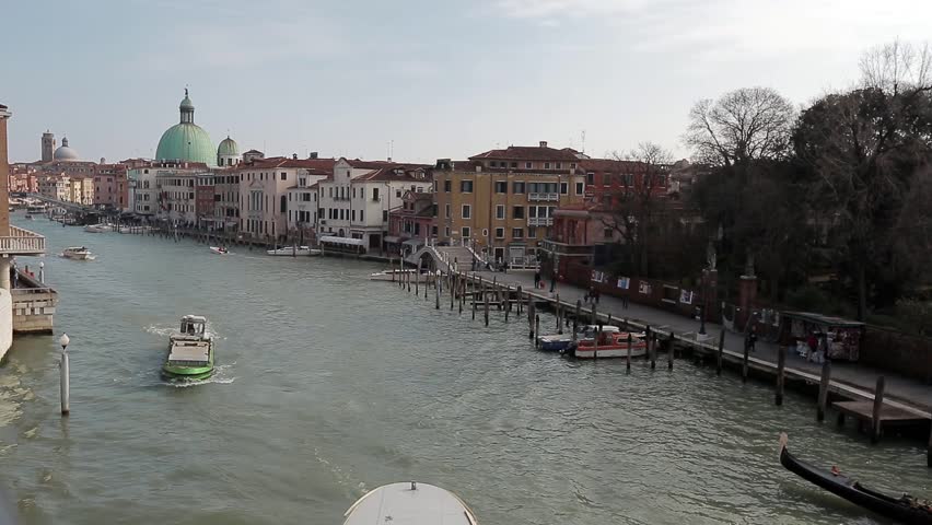Gondolas and boats pass by on the Grand Canal near calatrava bridge. Italy. Venice is a UNESCO World Heritage Site and a popular tourist destination.