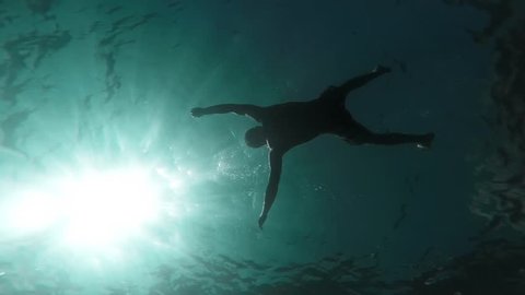Silhouette Man Drowning Sinking Body In Deep Water Slow Motion Underwater Shot Ocean Murder Danger Lost At Sea Drown Death Lifeless Swimmer Sun Rays Waves Ripples Mortality Concept Gopro HD