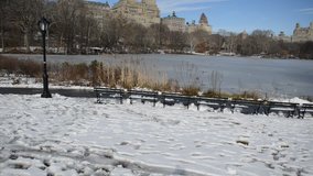 Vertical Panning HD video of Central Park with snow showing Upper West Side skyline, Manhattan skyline, New York City