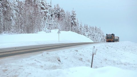 SEGEZHA, KARELIA, RUSSIA - CIRCA DEC, 2014: Cargo trucks drive to the Murmansk city direction on the Kola route in Karelian woods at winter season