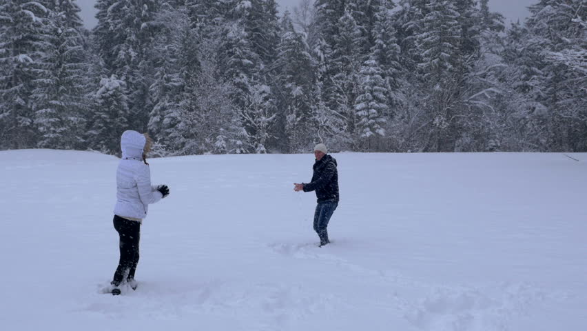 Couple having a snowball fight and hugging at the end