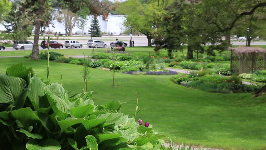 Niagara Falls with landscaped gardens in front of American Falls on Canadian side. Unrecognizable people in background