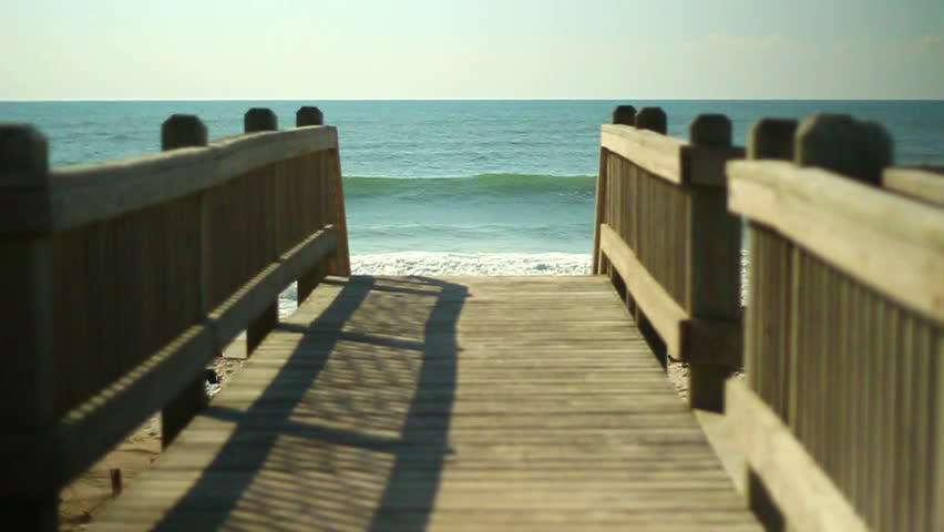 Waves break on a sandy beach in the summer.