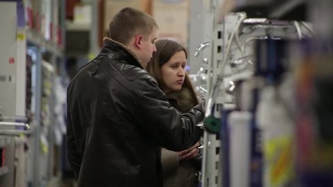 SAINT-PETERSBURG, RUSSIA, NOVEMBER 2013: Man and woman choosing a faucet in hardware store.