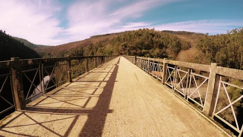 Point of view shot of riding a bicycle in Sever do Vouga, Portugal. Features a wide view of the bike track crossing a bridge.