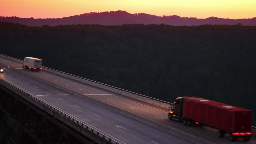 Traffic passes over the New River Gorge Bridge spanning the New River at dusk.   This bridge is a  steel-arch bridge, in Fayetteville, West Virginia, United States. 