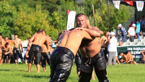 ISTANBUL, TURKEY - AUG 24, 2012: 8th Sile Annual Turkish Oil Wrestling Event. Tired wrestlers trying to grab each other
