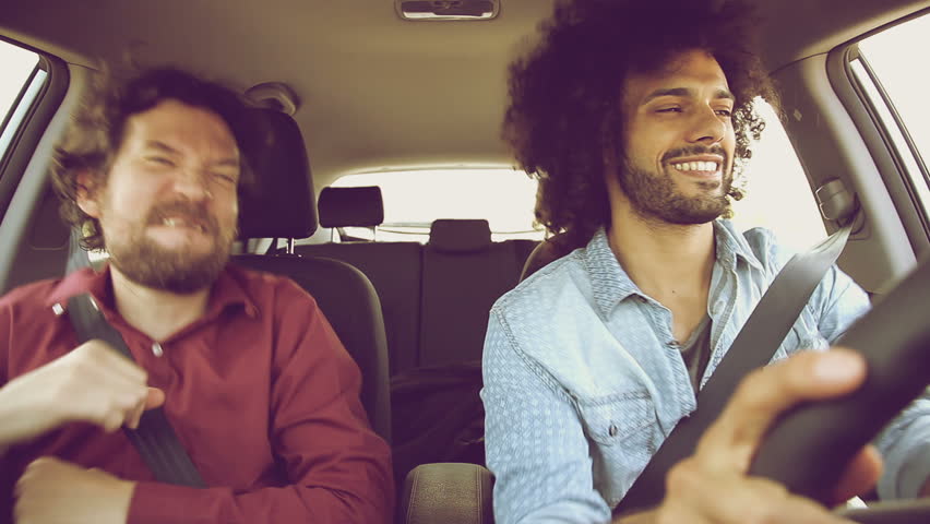Two funky cool hipster men driving car dancing retro style