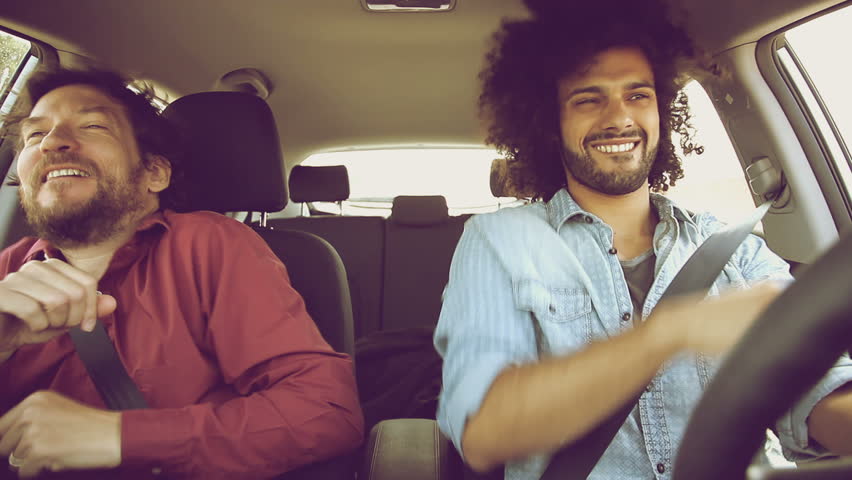 Two funky cool hipster men driving car dancing retro style