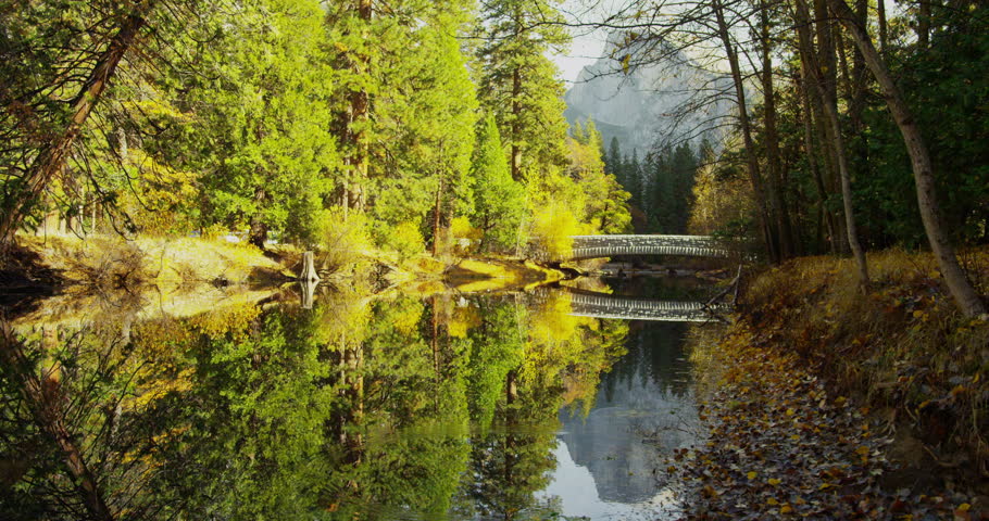 Mountains are reflected in Merced River at Yosemite National Park, California. Half Dome and Sentinel Bridge can be seen in the distance.  Shot on Red Epic.