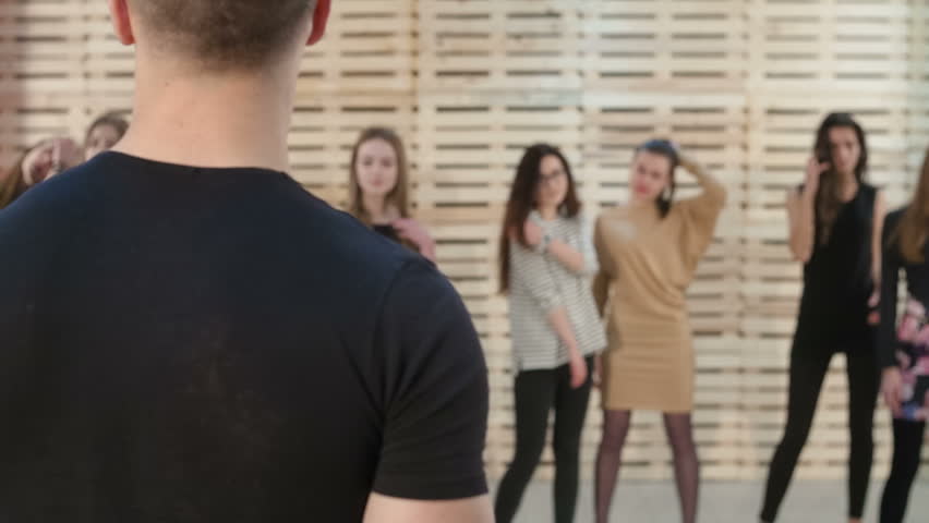 Casting models for a fashion show - Group of girls models posing in front of both male