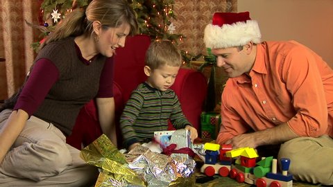Mother, father and son in pajamas opening Christmas presents Stock Video