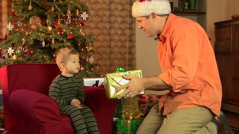 Father and little boy in pajamas opening Christmas present  Stock Video