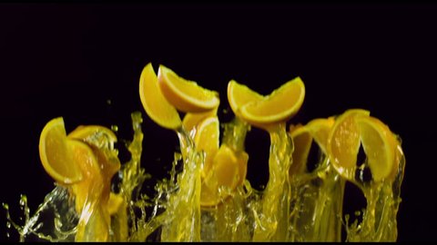 orange slices fly with splashes of juice, slow motion