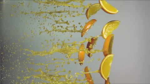 orange slices fly with splashes of juice, slow motion