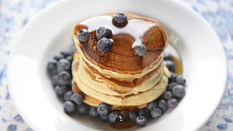 Delicious hot pancakes with fresh blueberries and natural maple syrup