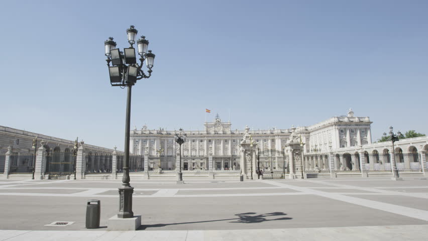 Young couple walking holding hands happy and romantic in front of Royal Palace of Madrid, Spain, Tourists traveling in Europe visiting Spanish tourist attractions landmarks, Palacio Real de Madrid.