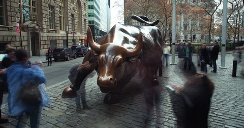 New York, NY, USA, November, 22, 2010: Timelapse video of Wall Street Bull with tourists taking pictures and city traffic in the financial district of downtown Manhattan during the day.