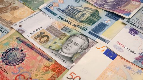 Various currency notes background. Dollar, Euro, Yuan, Lira, Kuna, Shekel and others. Dolly shot.  4K, UHD