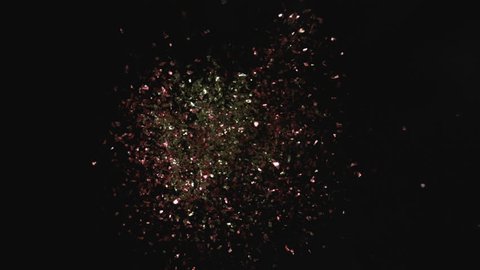 Camera follows colorful confetti flying after being exploded against black background. Shot with high speed camera, phantom flex 4K. Slow Motion. Unedited version is included at the end of clip.