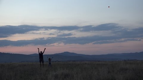 4K Happy Family Trying Lifting a Chinese Lantern on Sky in Sunset then Waving Goodbye, Father, Man and his Little Girl, Kid having Fun Together in Mountains in Summer Vacation